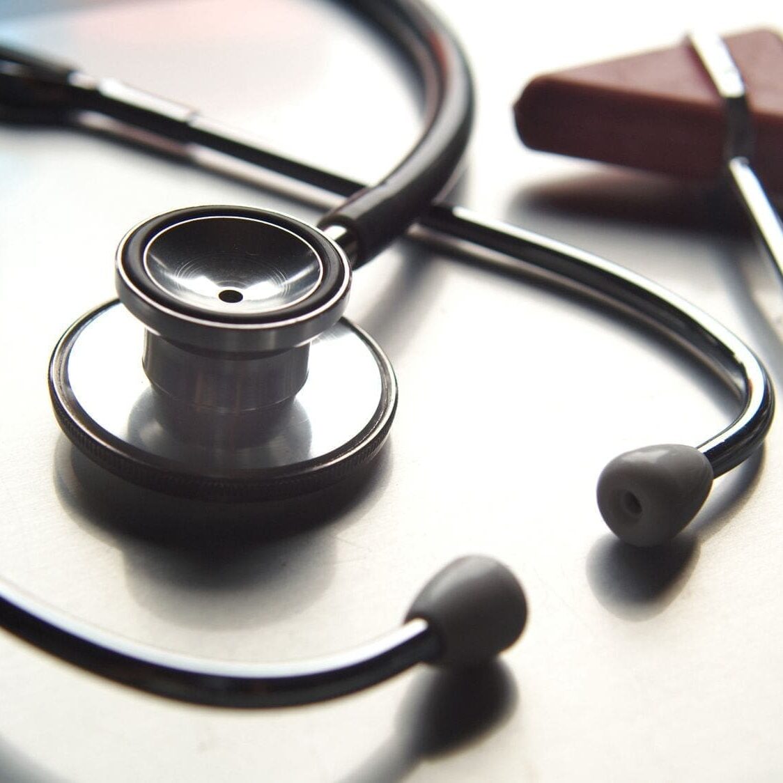 A stethoscope and ear buds are sitting on the table.