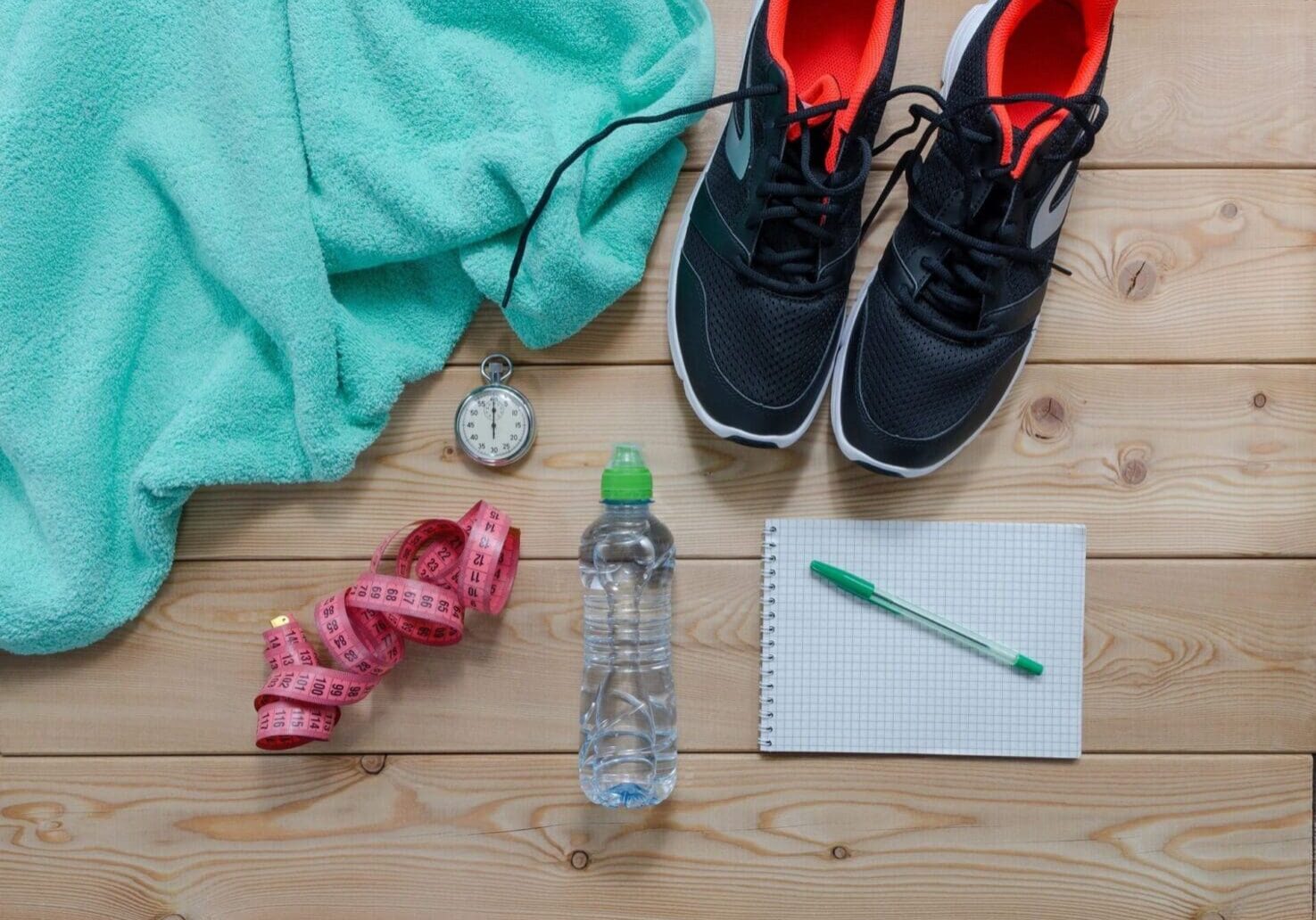 A pair of shoes, water bottle and measuring tape.